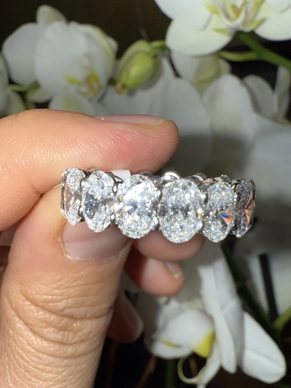 Oval diamond eternity band worn on a hand